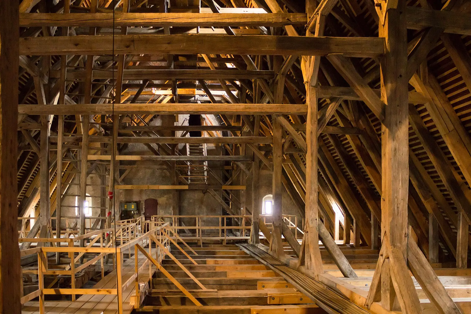 Historischer Dachstuhl aus massiven Holzbalken, warm beleuchtet